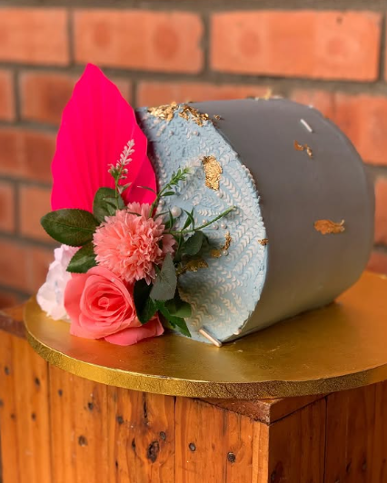 Bolo cinza e azul com textura e flores cor-de-rosa
