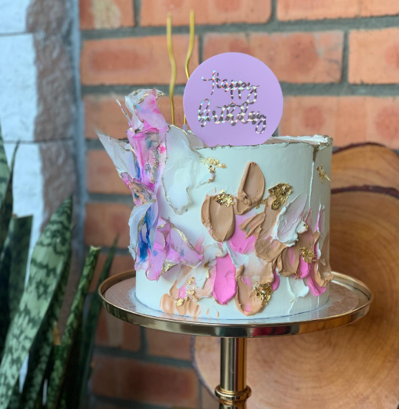 Bolo com buttercream pintado em rosa e dourado e topo de aniversário